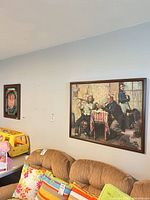 Wide view showing both framed pieces on wall above couch