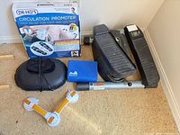 Group shot of all items including boxed Circulation Promoter, mini stepper, yoga block, massage pad, suction exerciser