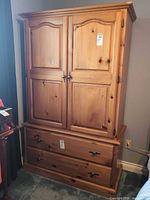 Front view of pine armoire showing doors and lower drawers
