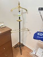 Full view of brass and iron valet stand showing hanger, tray, trouser bars and overall condition