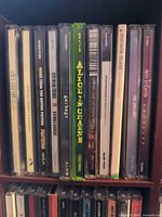 Row of mixed rock/alternative CD jewel cases on a shelf with clearly visible Alice in Chains title