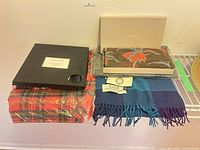 Overview of five scarves showing packaging and tags