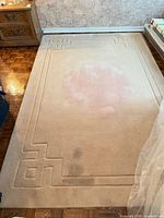 Full view of rug showing central discoloration and border design