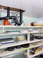 Shelves with assorted pots, pans, baking dishes, kitchen scale