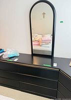 Front view of dresser with arched mirror and brass trim