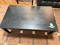 Top view of black engineered wood coffee table showing wood grain and wear