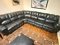 Full view of entire black leather sectional sofa set up in L-shape