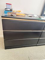 Front view showing three drawers and gold trim