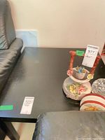 Top and left side of black square end table beside leather sofa