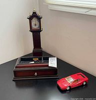 Clock and jewelry tray with Ferrari model car on tabletop
