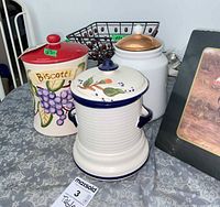 overview of three ceramic canisters and wire basket