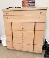 Front view of chest showing five drawers and brass pulls
