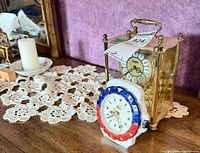 Heirloom mantel clock and Esquire white/red/blue desk clock on table