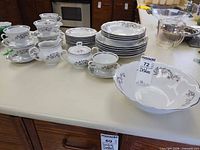 Full lot showing stacks of plates, cups, saucers, creamer, sugar with lid, serving bowl