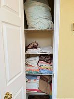 Closet shelves with multiple stacks of bath, hand and wash towels in various colors
