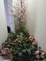 Full view of mixed faux plants with blossom stems and figurines