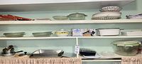 Overall shelf view with majority of glass bakeware, cookware, storage containers, boxed cookie press visible