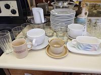 Overview showing plates, bowls, glasses, mugs and serving pieces