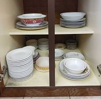 Cabinet interior showing entire assortment of plates, bowls and saucers