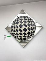 Full view of diamond-oriented square mirror artwork on wall