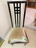 Front angle of chair showing high slat back and seat upholstery