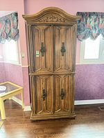Front view of full armoire showing doors, crown and hardware