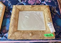 Front view of square ornate gold fabric mirror