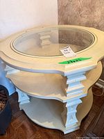 Top view of painted round end table showing glass insert and cream finish