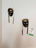 Both black and gold Venetian masks mounted on wall