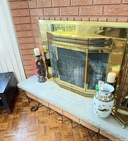 Overall view on hearth showing candlestick, fireplace, vase