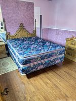 Queen bed set assembled showing wooden headboard, mattress, box spring, metal frame not visible