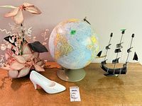 Full lot showing globe, ship sculpture, faux flowers, ceramic shoe