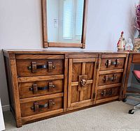 Front view showing six drawers, center door, hardware