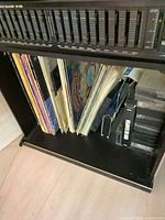 Shelf showing vertical stack of LPs beside cassette tapes