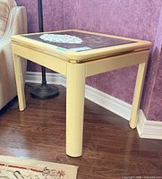 Full view of table showing cream frame, glass top, gold trim