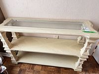 angled front view of console table showing three tiers and glass top