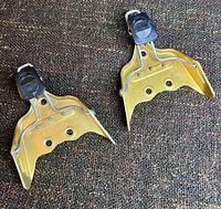 Both gold metal ski binding toe brackets, top view
