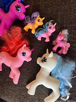 Group of seven My Little Pony figures displayed on fabric surface