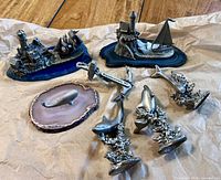 All eight pewter nautical figurines displayed on paper backing