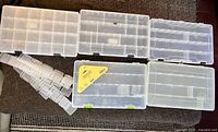 Five clear tackle boxes laid out with bundle of spare dividers