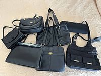 Group shot of all seven black handbags