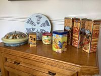 Group view of all eight tins on dresser