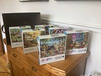 Six puzzle boxes and storage cube displayed on cabinet