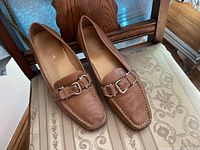 Top view of Geox brown leather loafers on chair