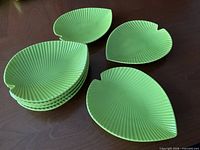 stack of eight green leaf-shaped melamine plates