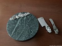 top view of green marble cheese board with cleaver and spreader