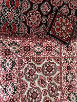 Bedspread showing both cream and black sides, fringe, one pillow and mat