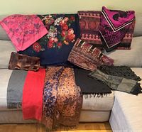 Full lot overview on sofa showing all scarves, shawls and pashminas