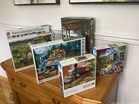Five of the six 1000-piece puzzle boxes grouped on cabinet