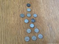 All fourteen coins laid out on tabletop showing size and colour.